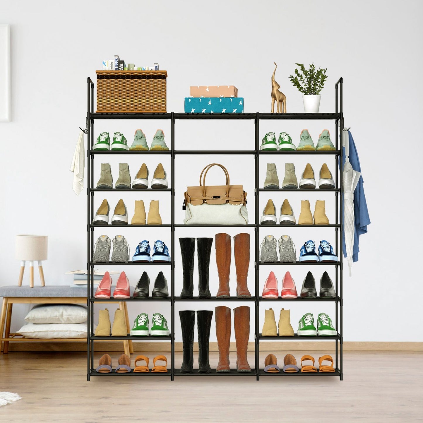 Modern black shoe rack displaying various styles of footwear including sneakers, boots, and sandals, with a wicker basket and decorative items on top, set in a stylish living space.