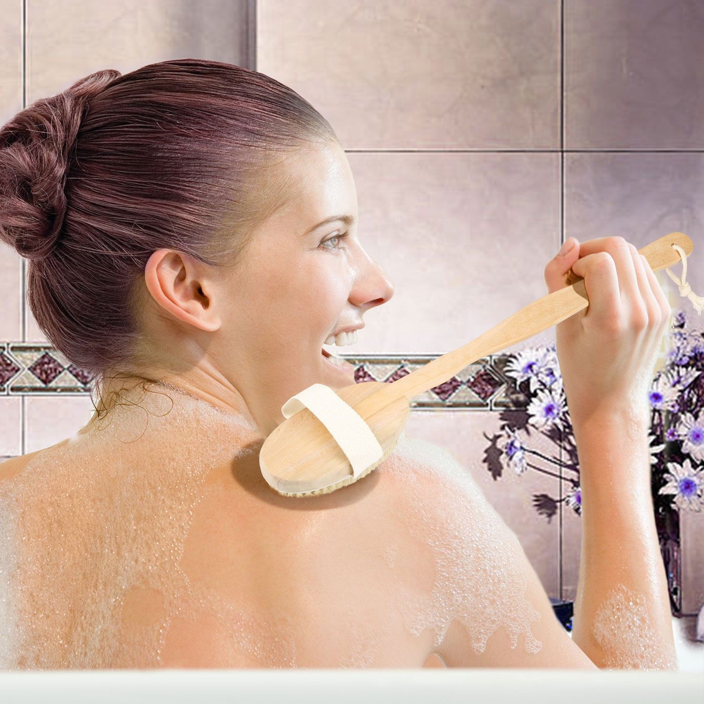 Person using a wooden scrub brush on their back while enjoying a relaxing bath surrounded by decorative tiles and flowers.