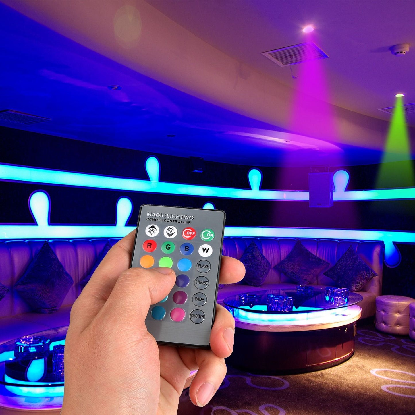 Remote control for magic lighting in a vibrant, colorful lounge setting with LED accents and plush seating.