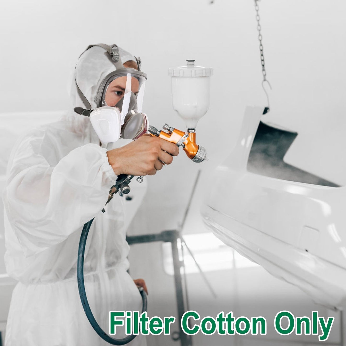 Professional painter in a white protective suit using a spray gun to apply paint in a modern workshop environment, showcasing high-quality filter cotton only.