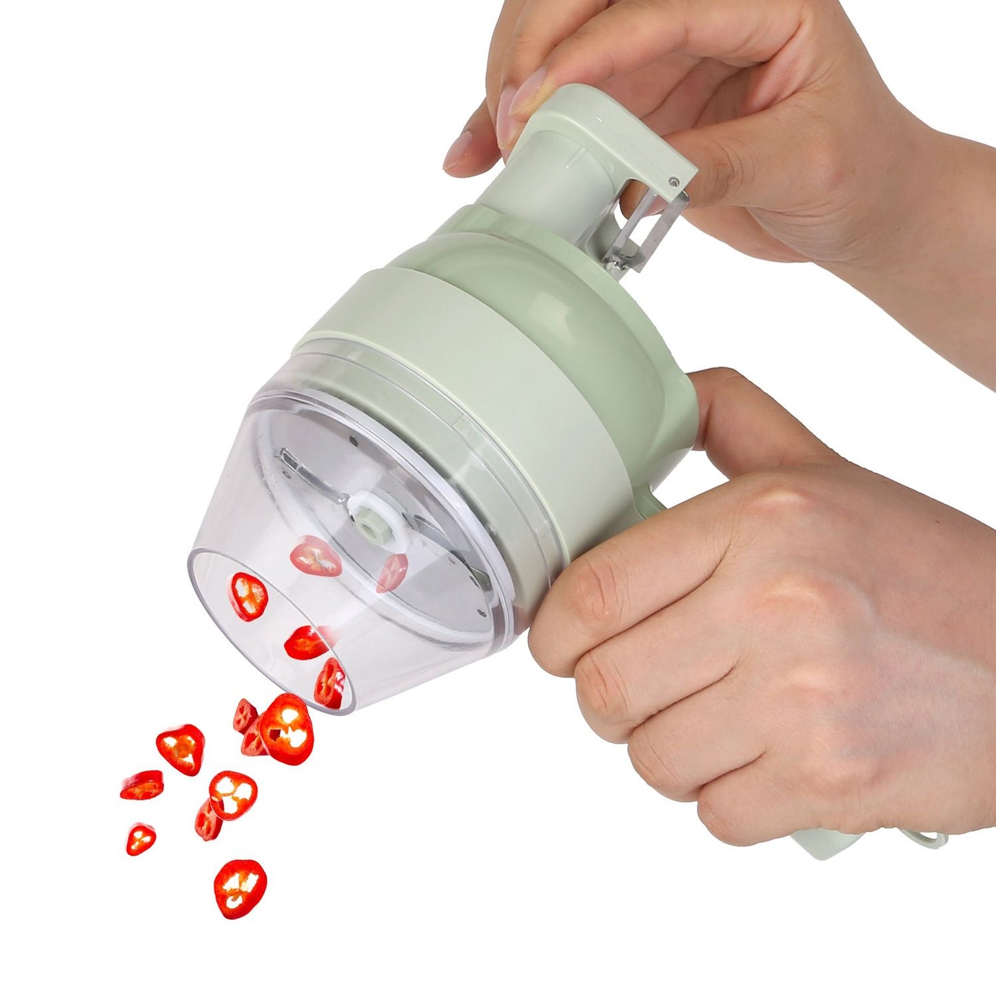 Handheld vegetable slicer showing sliced red chili peppers being dispensed from the clear container, with a pale green exterior and ergonomic grip for easy use in the kitchen.