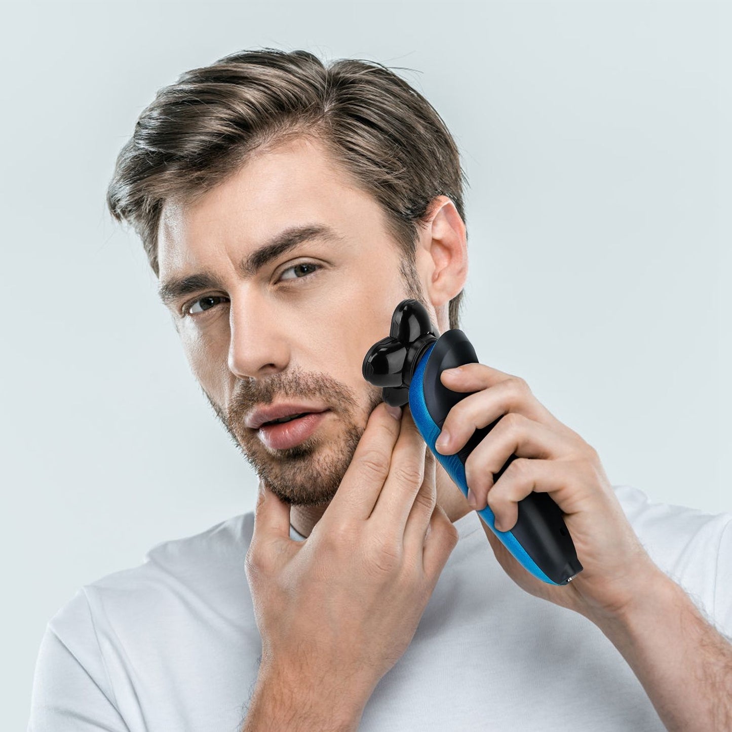 Man using a modern electric trimmer to groom facial hair, showcasing its sleek design and ergonomic handle against a light background.