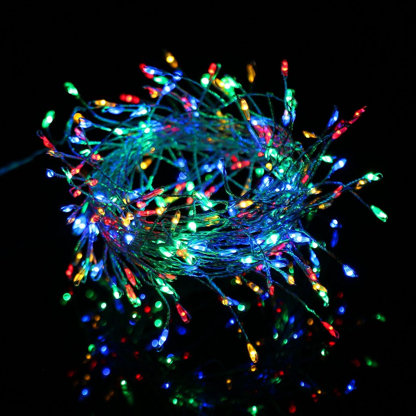 Colorful LED string lights in a tangled bundle, featuring vibrant red, green, blue, and yellow bulbs shining against a dark background, ideal for festive decorations and ambiance.