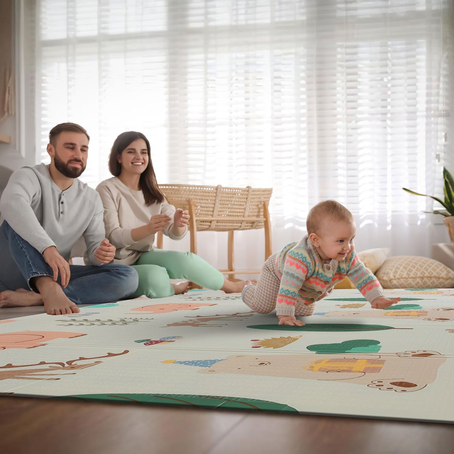 Baby crawling on a colorful, illustrated play mat while parents sit nearby, creating a cozy family scene in a bright, airy living room.