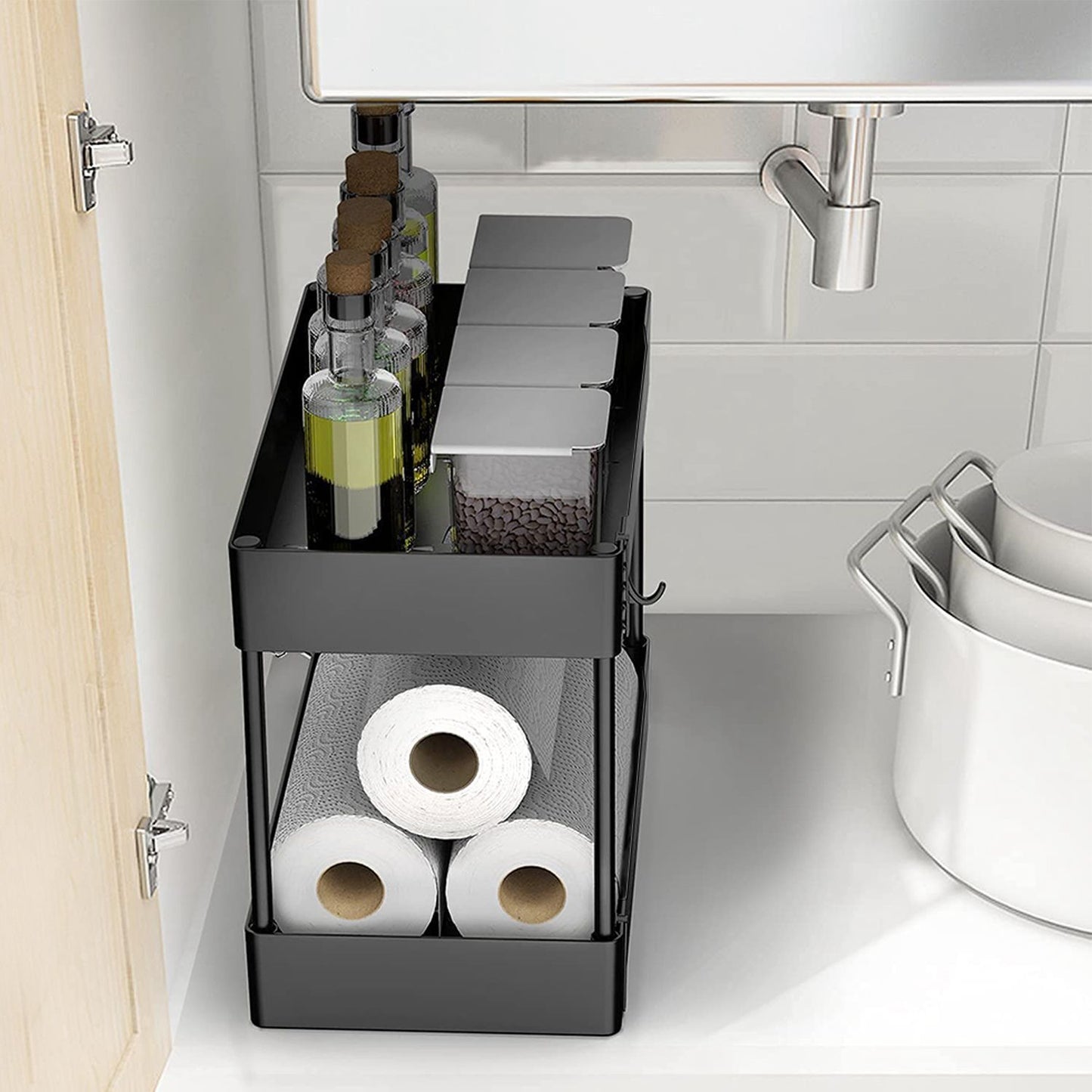 Under-sink storage organizer with glass bottles for oils and spices, containers for condiments, and rolls of paper towels in a sleek black design.