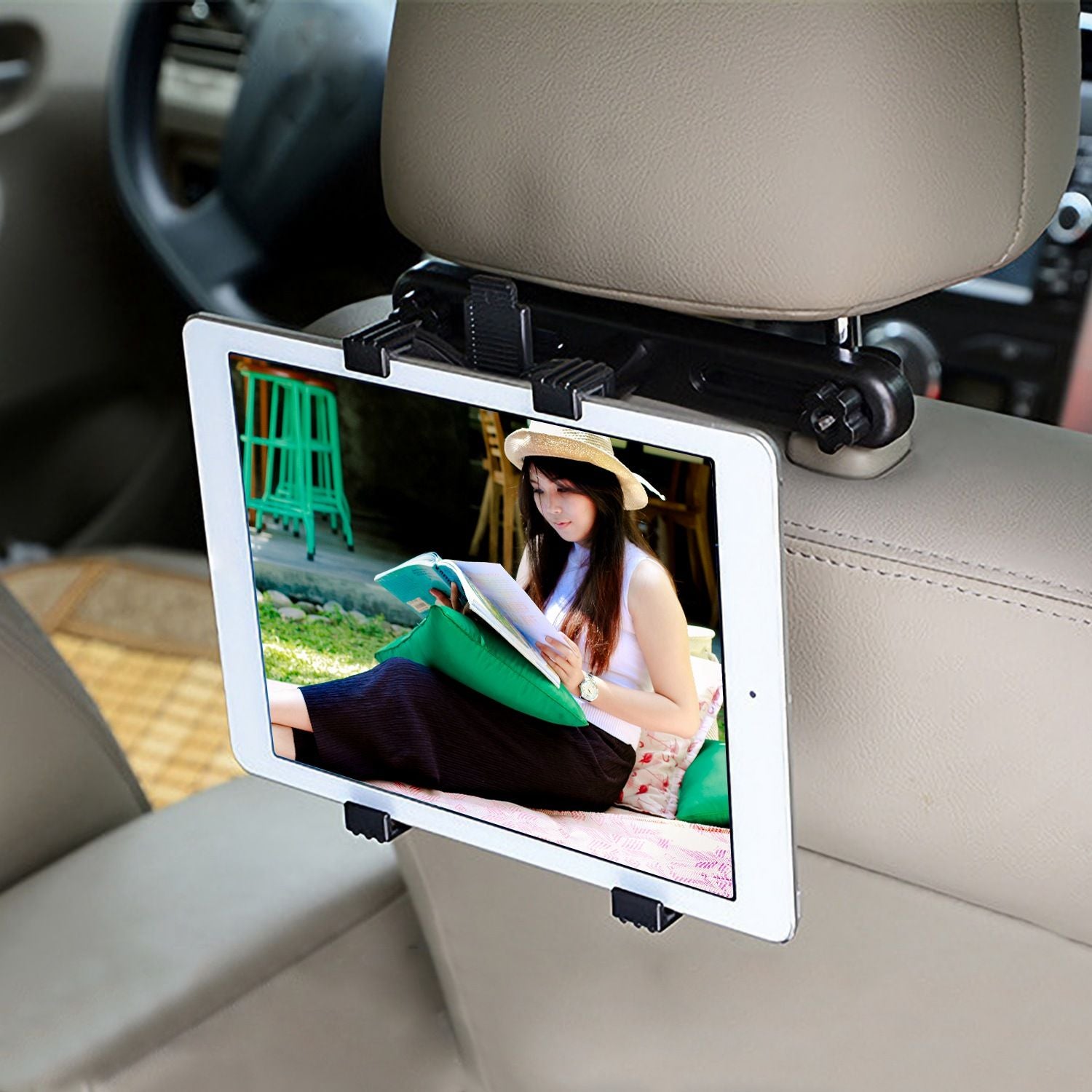 Tablet holder mounted on a car headrest, displaying a person reading a book while relaxing, perfect for rear passenger entertainment.
