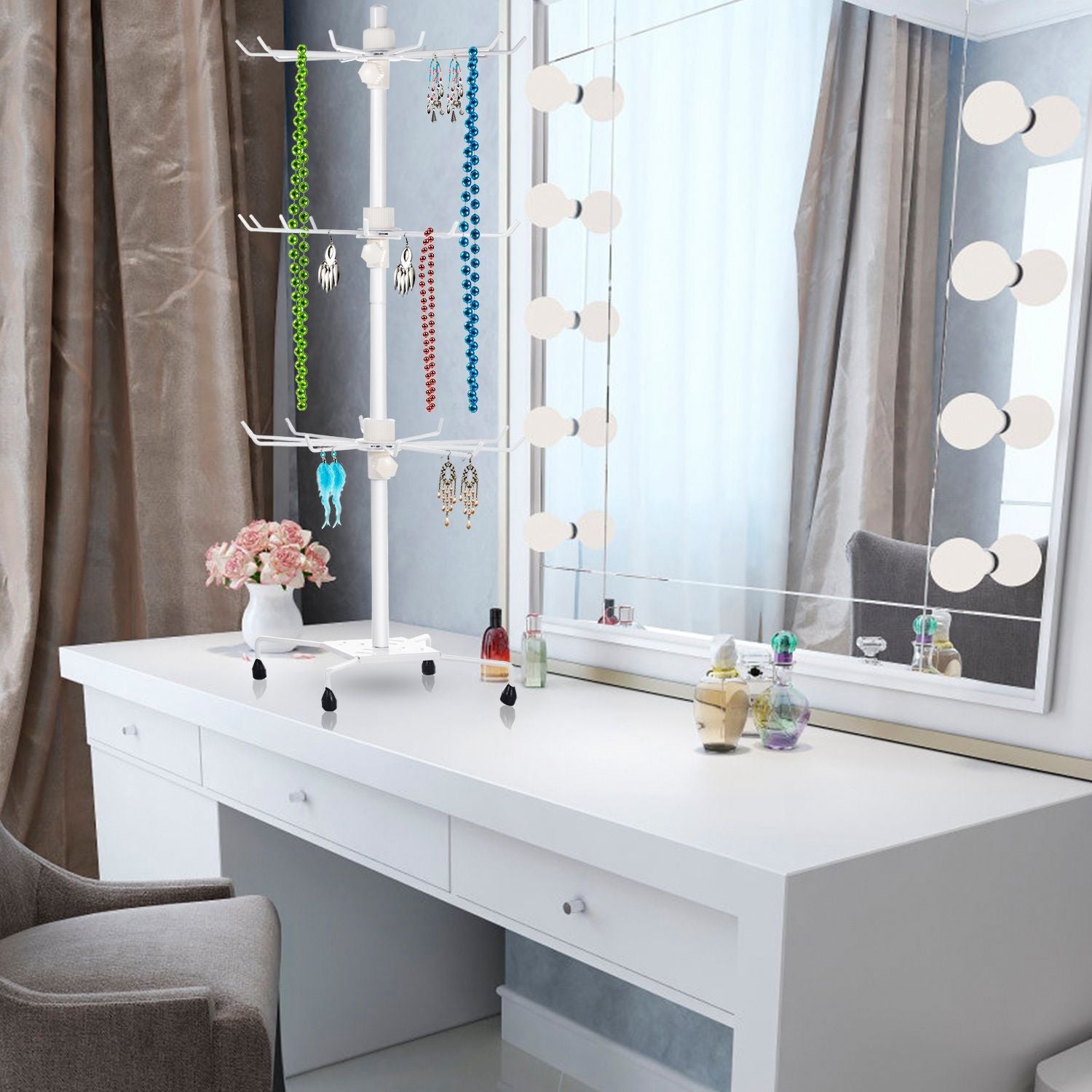 Jewelry organizer display stand on a modern white vanity with colorful necklaces and earrings, surrounded by beauty products and a mirror reflecting natural light.