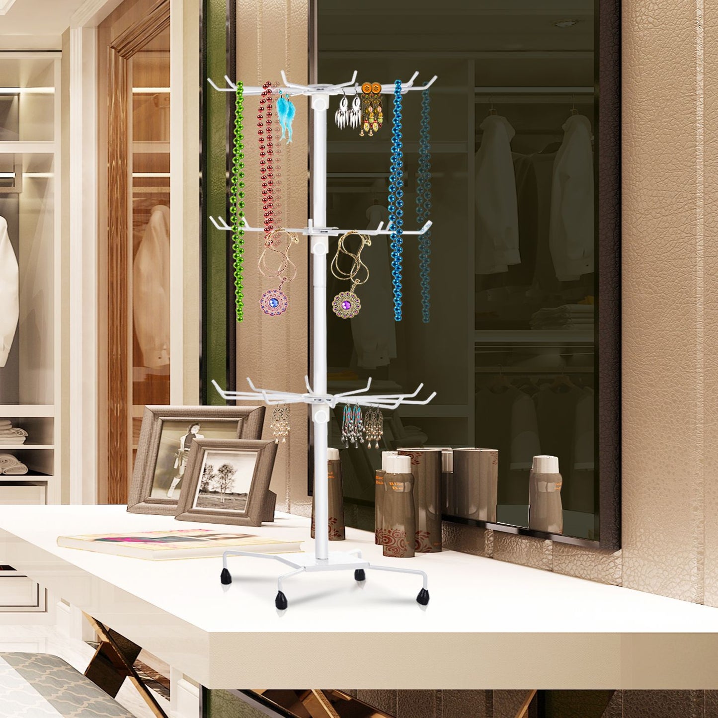 Jewelry organizer standing on a white table, displaying colorful necklaces and earrings on a multi-tiered rack, set in a stylish modern dressing room.