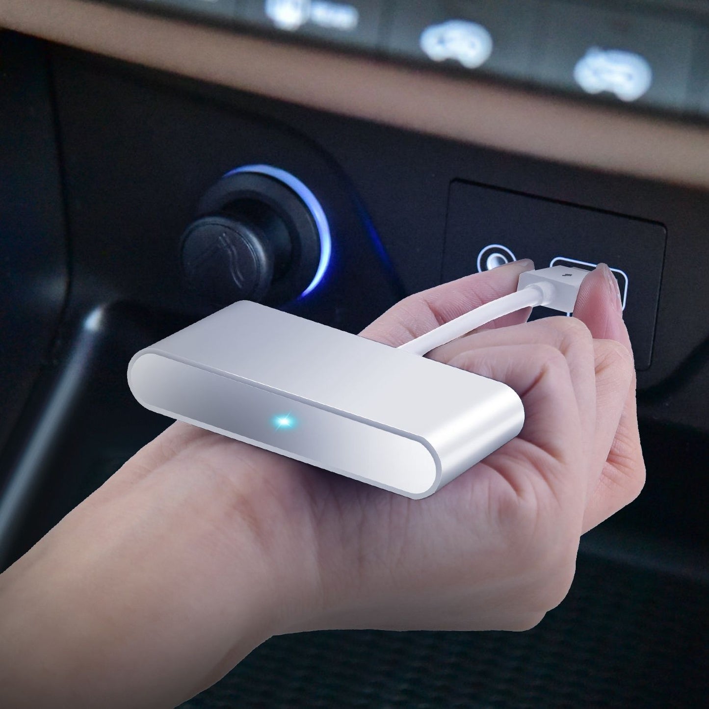 Compact silver car charger held in a hand, with a blue power indicator, connecting to a vehicle's charging port.