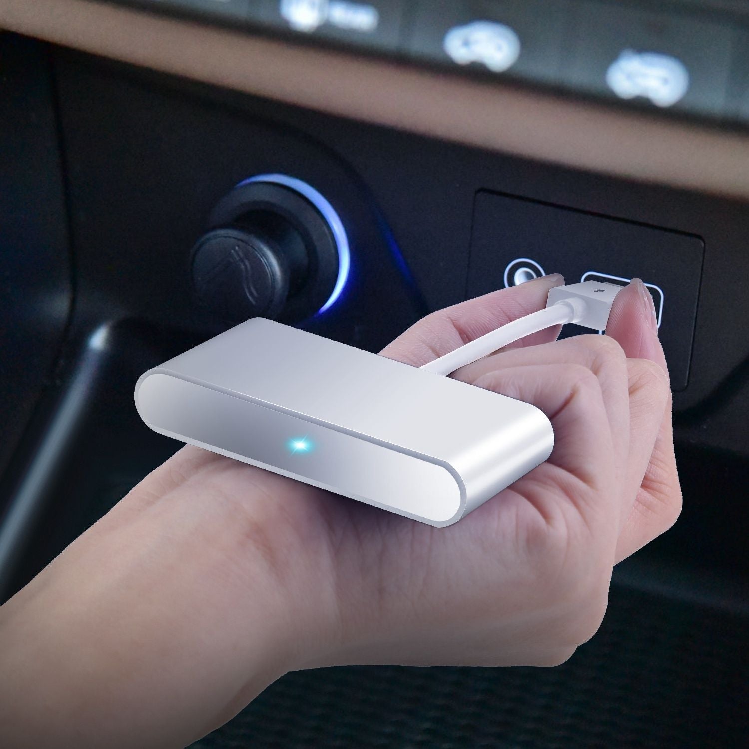 Compact silver car charger held in a hand, with a blue power indicator, connecting to a vehicle's charging port.