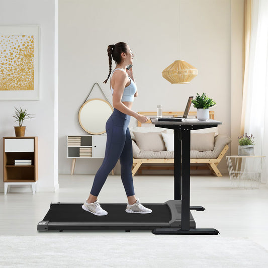 Home office treadmill with adjustable standing desk, featuring a woman walking while using a laptop in a modern living space.