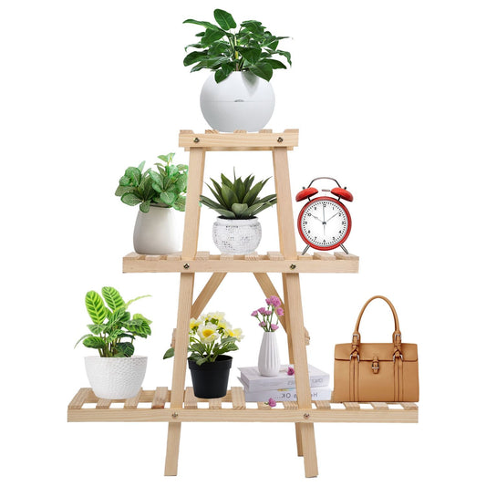 Wooden plant stand displaying various potted plants, a red alarm clock, a handbag, and books on a white background.