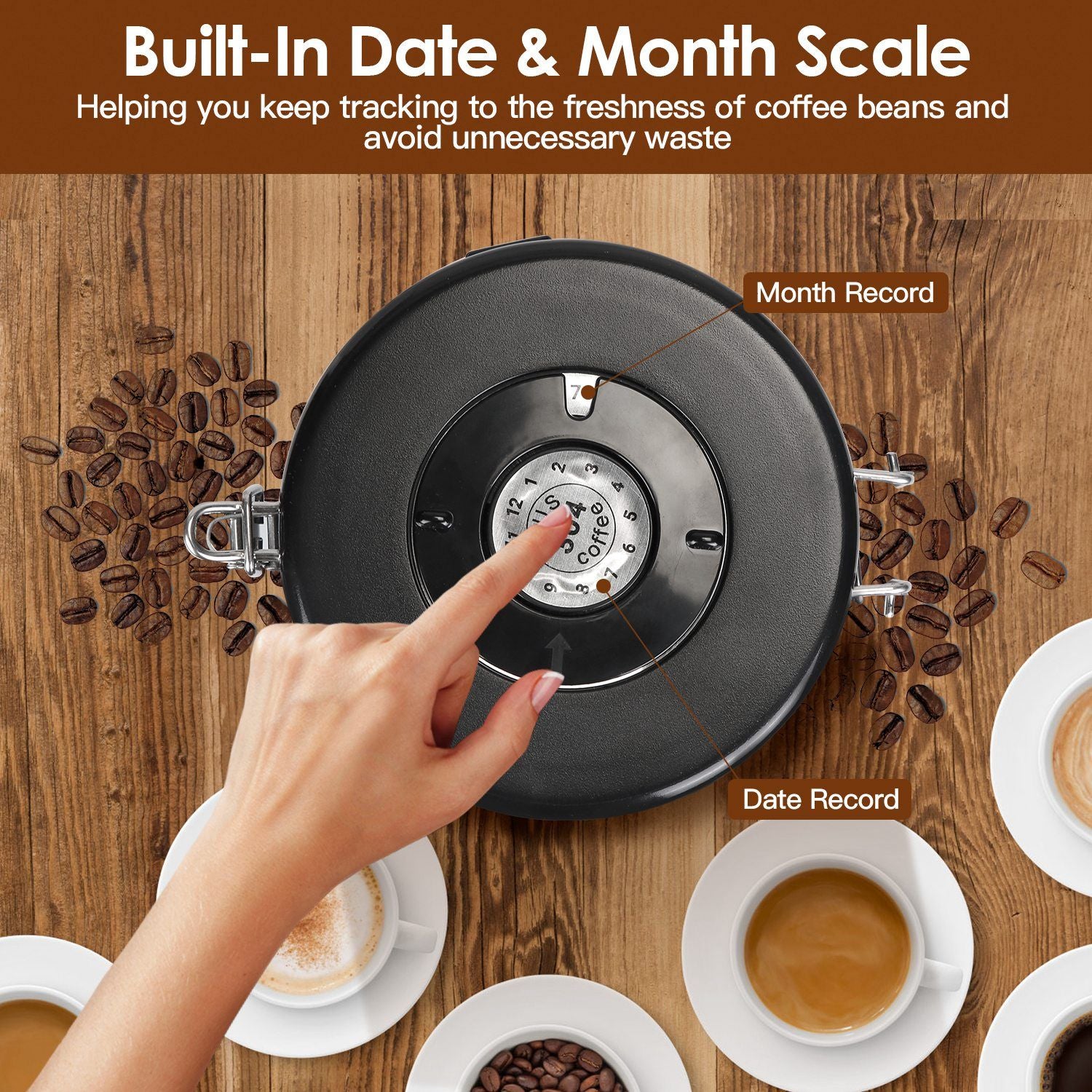 Hand adjusting the built-in date and month scale on a coffee storage container to track freshness, surrounded by coffee beans and cups of coffee on a wooden surface.