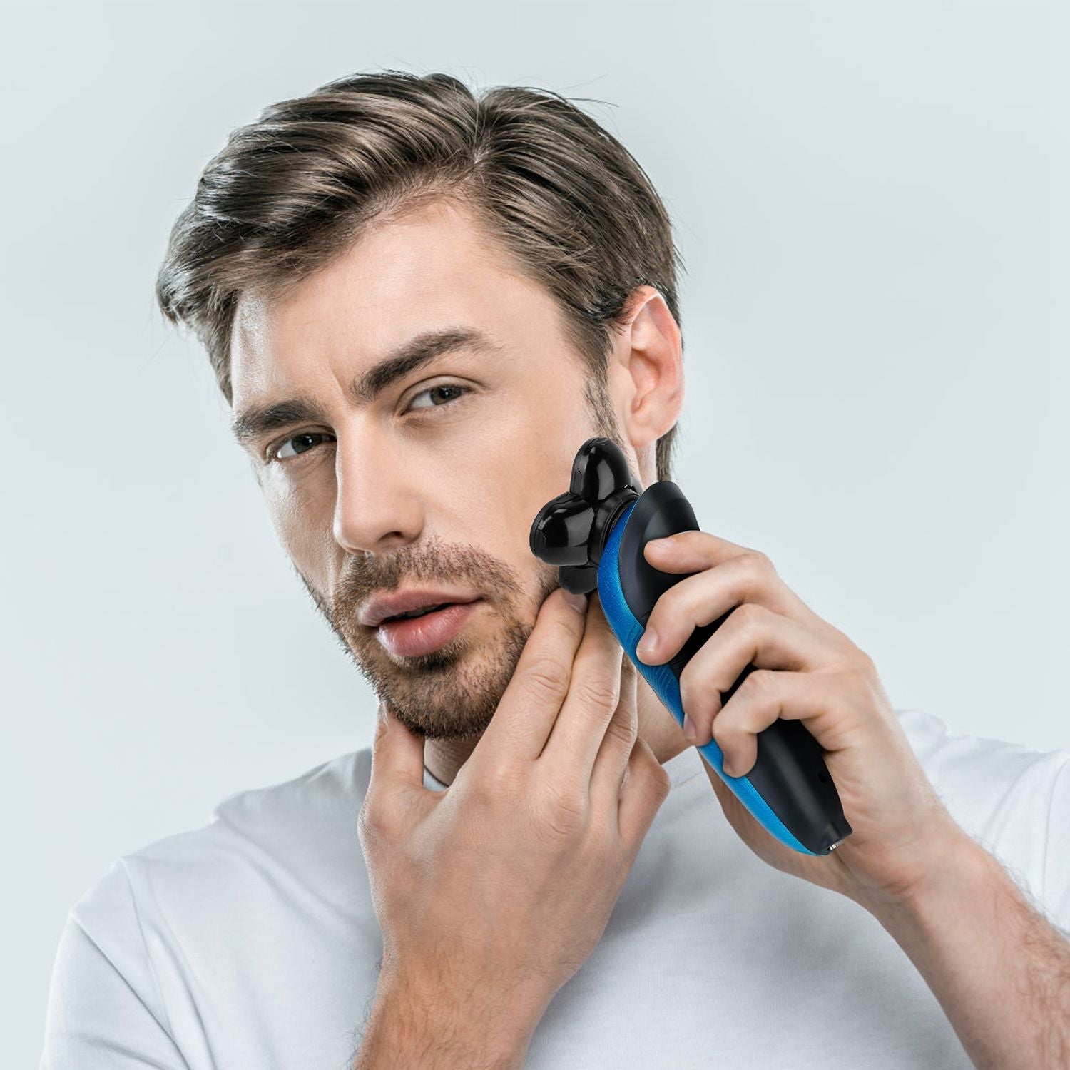 Man using a modern electric trimmer to groom facial hair, showcasing its sleek design and ergonomic handle against a light background.