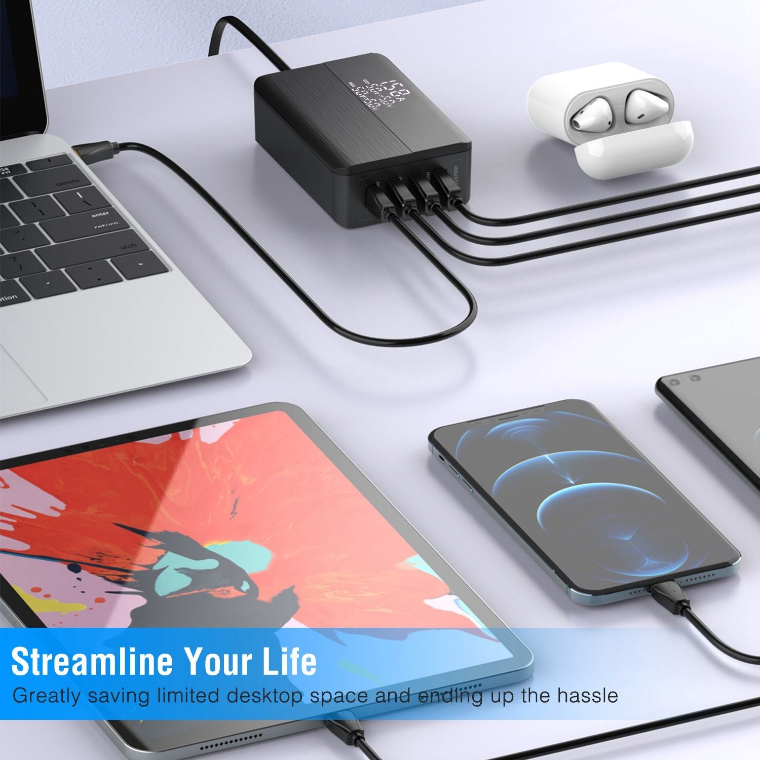 Black multi-device charger with multiple USB outputs connected to a laptop, a tablet with colorful artwork, and two smartphones on a clean desktop, promoting efficient organization and space-saving.
