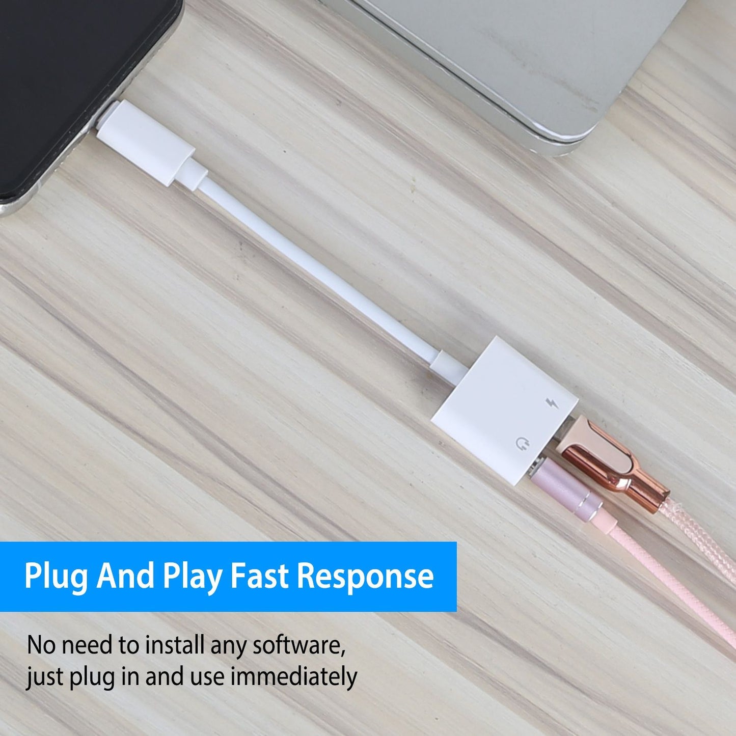 White audio adapter and charging cable connected to a smartphone on a wooden surface, with a caption highlighting its plug-and-play fast response feature for immediate use without software installation.