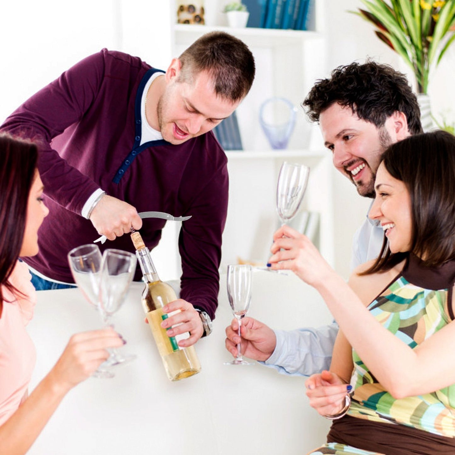 Group of friends celebrating with wine, one person uncorking a bottle while others hold glasses, festive atmosphere.