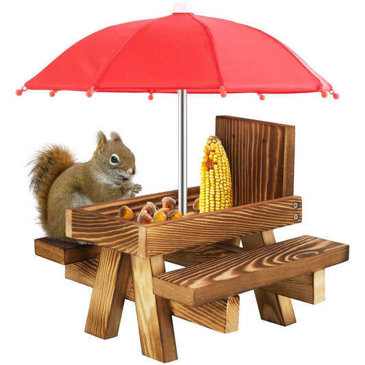 Squirrel picnic table feeder with red umbrella, featuring corn and acorns, designed for backyard wildlife feeding.