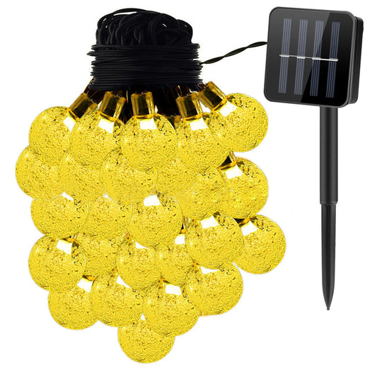 String of solar-powered yellow fairy lights with decorative globe bulbs and a solar panel stake for outdoor lighting.